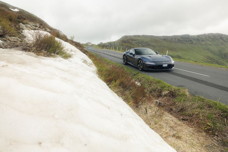 Ferrari 12Cilindri langs sneeuwresten op de bergweg