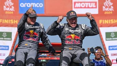 Team Audi Sport's Spanish driver Carlos Sainz (R) and his Spanish co-driver Lucas Cruzof (L) celebrate on their car after crossing the finish line of stage 12  of the Dakar rally 2024 from Yanbu to Yanbu, on January 19, 2024, at the end. Veteran Spanish driver Carlos Sainz won on January 19, 2024 the gruelling Dakar Rally for a fourth time on Friday, becoming at 61 the oldest winner of the race.
PATRICK HERTZOG / AFP